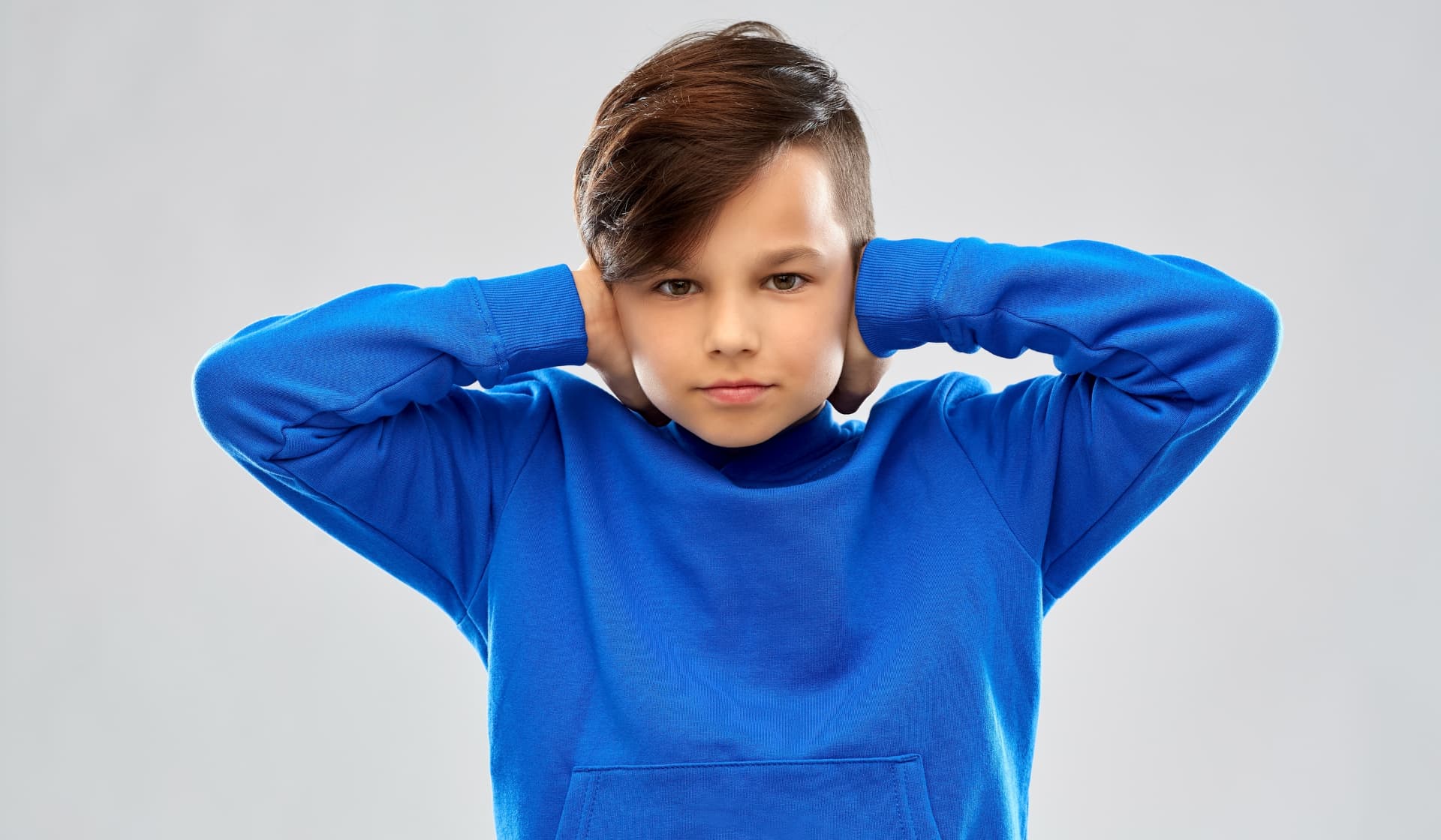 Sindrom Asperger dan autisme, anak laki-laki dengan kaus biru dan tangan di telinga